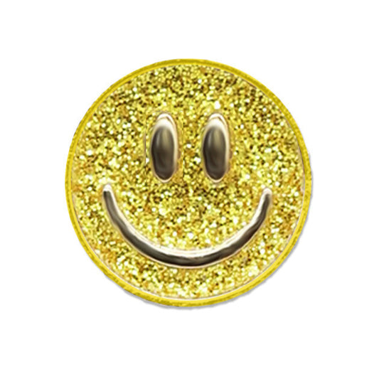 A gold-colored enamel pin with a glittery smiley face design.